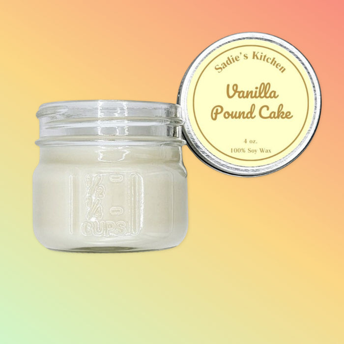 A mason jar candle with white wax, labeled 'Vanilla Pound Cake' on a yellow and orange background.