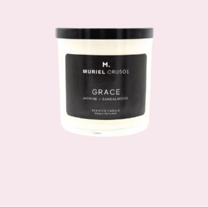 A medium-sized white candle with black lid, labeled 'GRACE Jasmine + Sandalwood', indicating it is a scented candle.