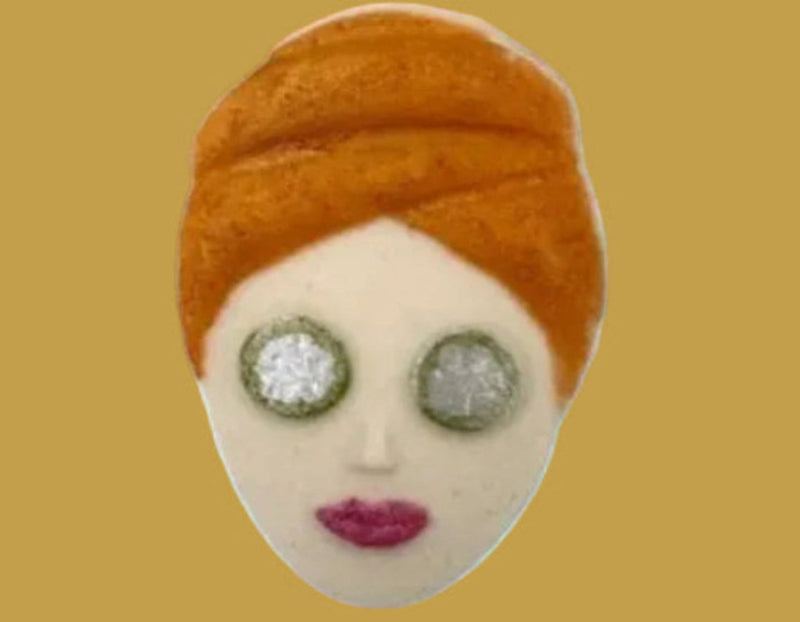 Felted art piece of a face with an orange headscarf on a white background