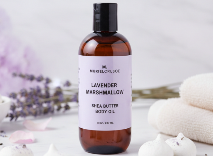 Shea butter body oil bottle with lavender marshmallow scent on a neutral background